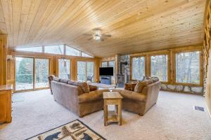 a living room with two couches and a tv at Betsie River Getaway in Thompsonville