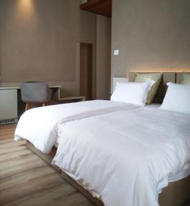 um quarto com uma cama grande com lençóis brancos e almofadas em Albergo Ristorante Palladio Osteria dal 1900 em Fratta Polesine