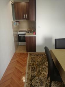 eine Küche mit einem Tisch und ein Esszimmer mit einem Teppich in der Unterkunft STAN na DAN PEX FREE PARKING in Vranje