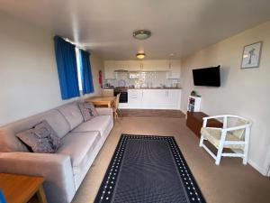 The Rose Cottage Inn في Selmeston: غرفة معيشة مع أريكة ومطبخ