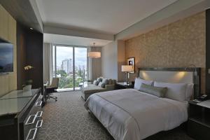 a hotel room with a large bed and a couch at InterContinental Real Santo Domingo, an IHG Hotel in Santo Domingo