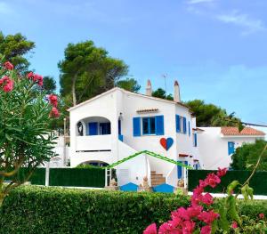 a white house with a heart painted on it at Apartamentos Ciutadella in Cala Blanca