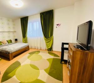a living room with a bed and a flat screen tv at Alisia House in Sibiu
