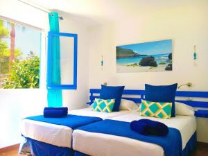 um quarto com 2 camas em azul e branco em Apartamentos Ciutadella em Cala Blanca