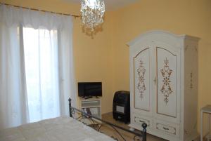 sypialnia z łóżkiem, telewizorem i żyrandolem w obiekcie Authentic Room w mieście Ronciglione