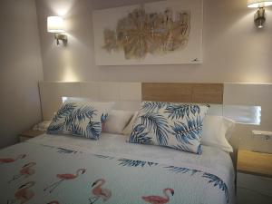 un dormitorio con una cama con flamencos rosas. en Apartamentos Playa Compostela, en Vilagarcía de Arousa