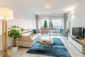 Una sala de estar con un sofá y un televisor. en Le Grand Large par Dodo à Cassis, en Cassis