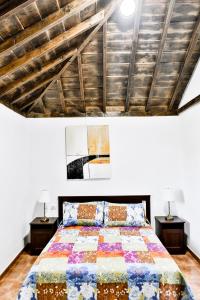 een slaapkamer met een bed met 2 nachtkastjes en 2 lampen bij CASA VILA in Garafía