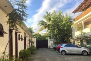 two cars parked in the driveway of a house at Pousada e Hostel Barra da Tijuca in Rio de Janeiro