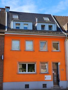 an orange building with windows and a roof at StayInCologne in Cologne
