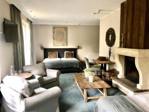 una sala de estar con un sofá y una cama en Landhuis Hotel de Hilkensberg, en Broekhuizen