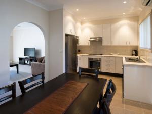 a kitchen and living room with a table and chairs at Dolphin Shores in Vincentia