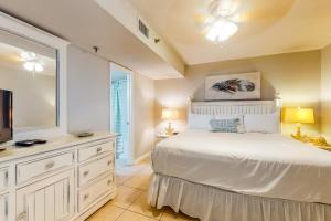 a bedroom with a white bed and a tv at Phoenix III in Orange Beach