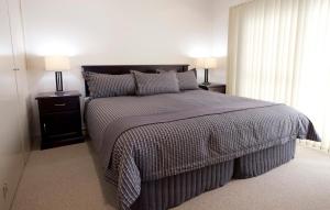 a bedroom with a large bed with two night stands at Dolphin Shores in Vincentia