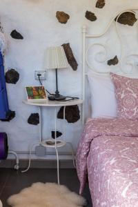 Guinea的住宿－BEAUTIFUL COASTAL HOUSE ON A TRANQUIL ORGANIC FARM，一间卧室配有一张床和一张带台灯的桌子