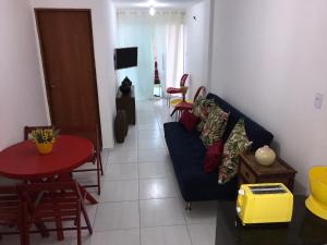 een woonkamer met een blauwe bank en een tafel bij FLAT PRAIA DOS CARNEIROS / TAMANDARÉ 06 TÉRREO in Recife