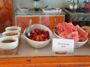- un comptoir avec des bols de fruits et un panneau indiquant que vous pourrez manger en français dans l'établissement Hotel Jardin Atacama, à San Pedro de Atacama