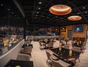 a restaurant with tables and chairs and a bar at Mitru Express Hotel in La Paz