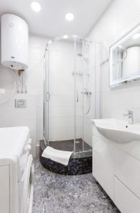 a white bathroom with a shower and a sink at Апартаменти "Kopernik" in Kyiv