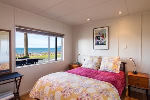 A bed or beds in a room at Golden Sand Beachfront Accommodation