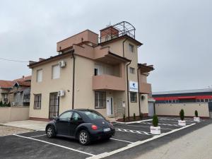 a car parked in a parking lot in front of a building at Airport view Apartment in Belgrade