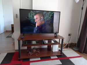 a flat screen tv sitting on a table with a phone at Departamento Ricardo in Viña del Mar