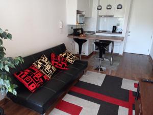 a black couch with pillows on it in a living room at Departamento Ricardo in Viña del Mar