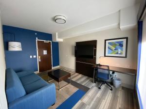 a living room with a blue couch and a desk at Holiday Inn Express Hotel & Suites El Dorado Hills by IHG in El Dorado Hills