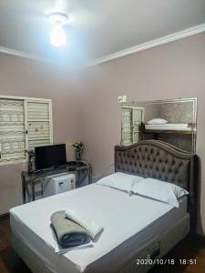 a bedroom with a bed and a desk with a computer at POUSADA DONA DORA 2 in Piauí