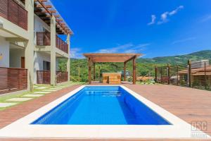 a swimming pool in the backyard of a house at Dunas Studios in Garopaba