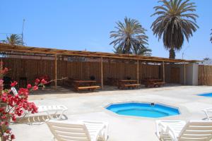 a resort with a swimming pool and palm trees at Casa Caravanas in Paracas