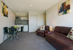 a living room with a leather couch and a table at Pinnacle Apartment in Nelson