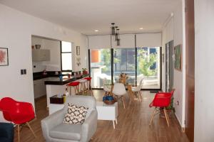 sala de estar con sillas rojas y cocina en Hermosos Días Soleados en Villa LUNA DEL MAR, en Telchac Puerto