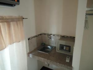 a bathroom with a sink and a microwave at SUITES Minimalistas in Guayaquil