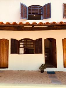a house with windows and a potted plant in front of it at Suite rustica in Paraty