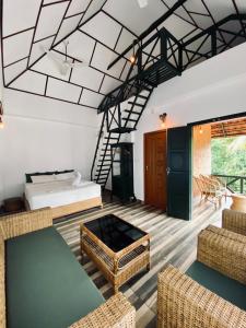 a room with a bed and a couch and chairs at Garggi Kumarakom Village Homestay in Kumarakom