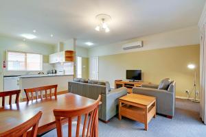 a living room with a table and a dining room at Traralgon Serviced Apartments in Traralgon