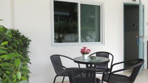 a table and chairs on a patio with a window at Bluemoon Studio Room in Ko Samed
