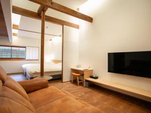 a living room with a couch and a flat screen tv at Maki No Oto Kanazawa in Kanazawa