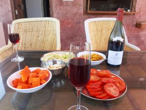 a table with a glass of wine and a plate of fruit at Corsican Haveli in Jodhpur +52 photos