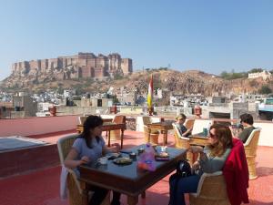 a group of people sitting at a table on a roof at Corsican Haveli in Jodhpur
