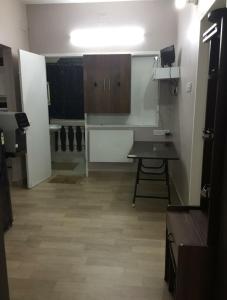 a room with a kitchen with a desk and cabinets at Avvairam Service Apartment - C9 in Chennai