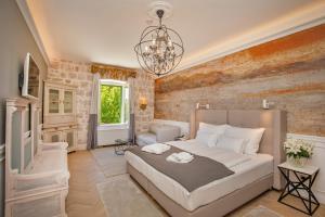 a bedroom with a large bed and a chandelier at Heritage Villa Nobile in Dubrovnik