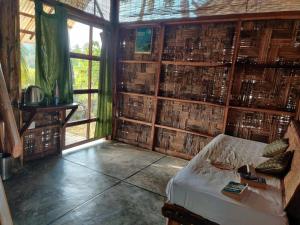a room with a wall filled with lots of books at Emerald Gecko, Neil Island in Neil Island
