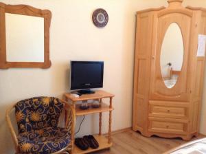 a room with a tv and a chair and a mirror at Guest Rooms Toni & Miro in Tryavna