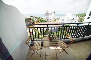 a balcony with two chairs and a view of the ocean at Lotus Wind Inn in Eluan