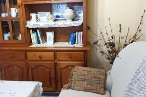 ein Wohnzimmer mit einem Holzschrank und einem Stuhl in der Unterkunft Casa del Cuetu. Traditional village house in Asturias in Meré
