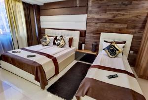 a bedroom with two beds and a wooden wall at Hotel Acktion in Shumen