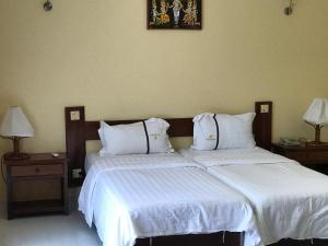 dos camas sentadas una al lado de la otra en un dormitorio en Don Bosco Hotel School, en Sihanoukville