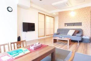 - un salon avec un canapé bleu et une table dans l'établissement Daiki Building 2, à Kyoto